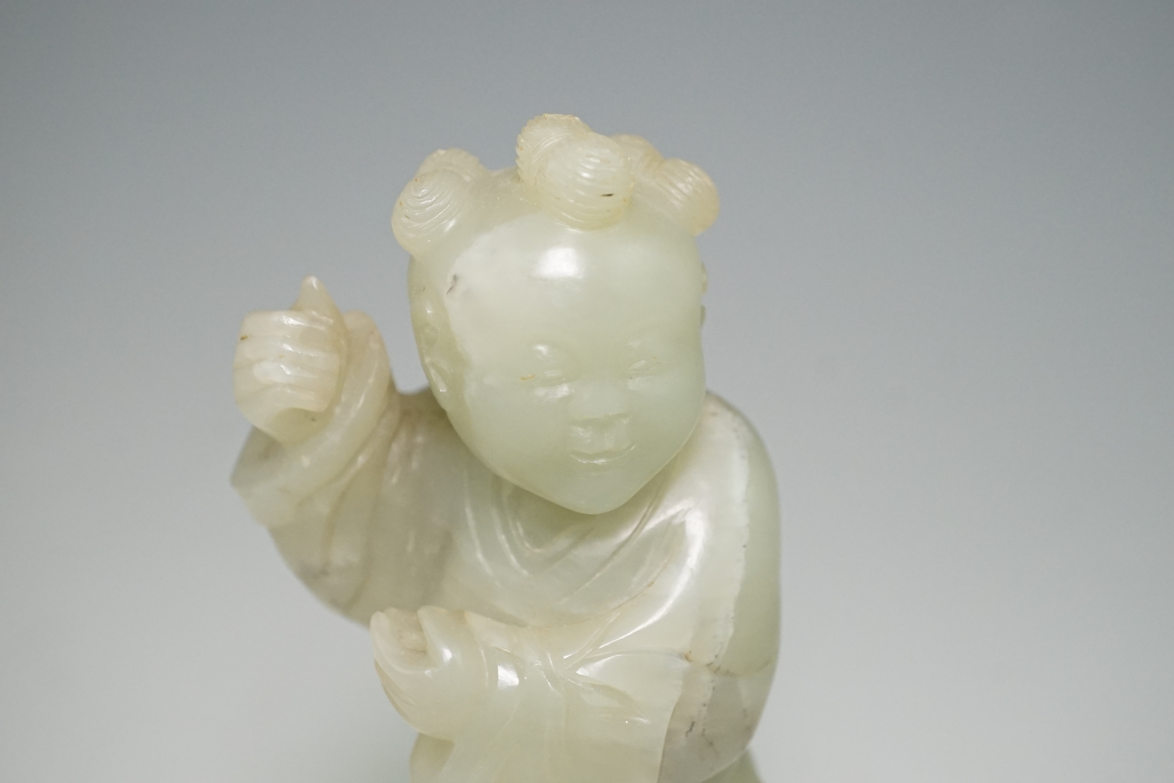 A Chinese pale celadon jade figure of a boy, 18th century